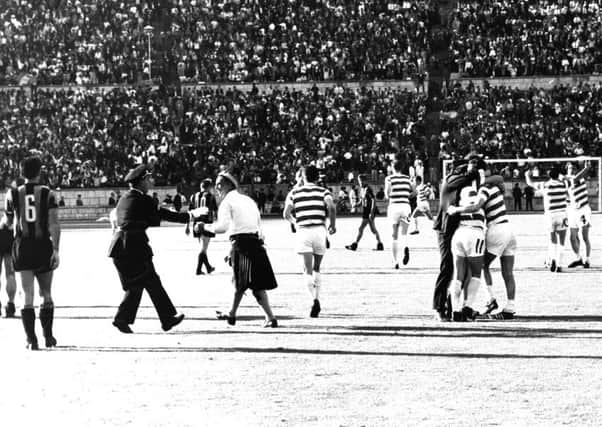 A Portuguese policeman tries to remove a Celtic fan, wearing a kilt, after he had run onto the pitch after Celtic had scored the winning goal against the Italians. Picture: contributed