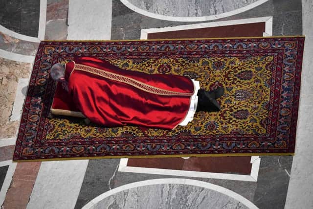 Pope Francis lies on the ground to pray during a mass for the Celebration of the Lord's Passion on Good Friday at St Peter's basilicaIa (photo: ALBERTO PIZZOLI/AFP/Getty Images)