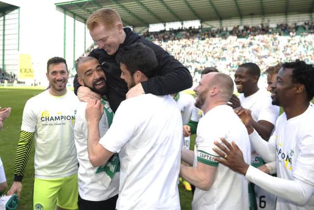 Hibs boss Neil Lennon, centre, celebrates the clubs title-winning victory over Queen of the South. Photograph: Neil Hanna