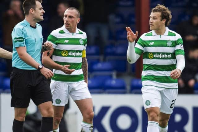Celtic's Scott Brown and Erik Sviatchenko confront referee Don Robertson after Ross County are awarded a penalty. Picture: Rob Casey/SNS