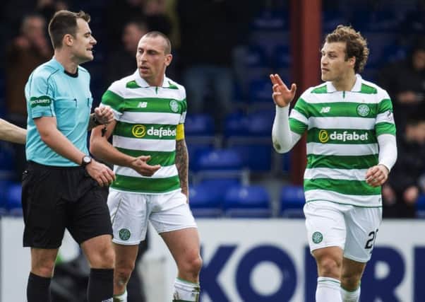 Celtic's Scott Brown and Erik Sviatchenko confront referee Don Robertson after Ross County are awarded a penalty. Picture: Rob Casey/SNS
