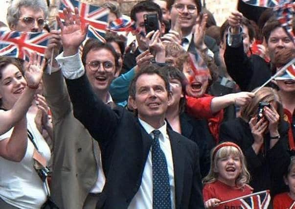Tony Blair waves at supporters upon his arrival at No. 10 Downing Street in 1997.