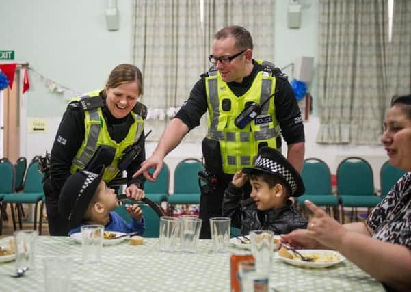 PCs Ferguson and ODonnell play with with a couple of Romanian children at the Community Canteen at Trinity Church, Daisy Street. Picture: John Devlin
