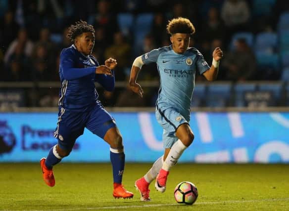Jadon Sancho, right, holds off Chelsea's Reece James in the recent FA Youth Cup Final First Leg match at The Academy Stadium. Picture: Getty Images
