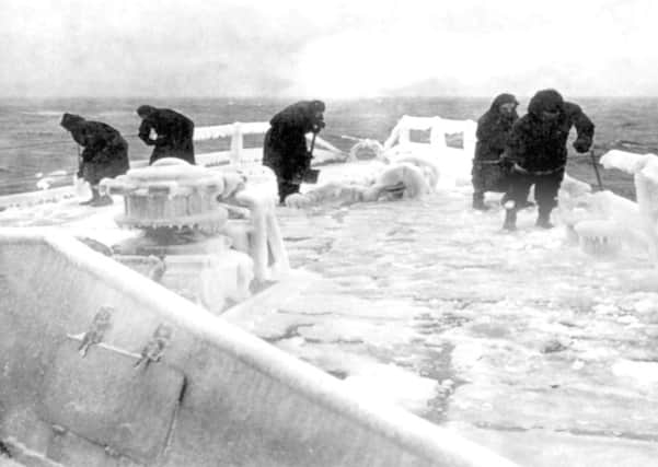 Sailors chip thick ice from the forecastle of the cruiser HMS Scylla.