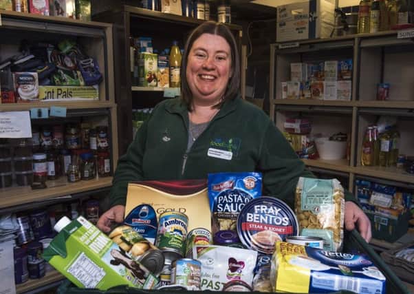 Kathleen Neilly displays a basket of food at the Foodbank in Whitburn, West Lothian.