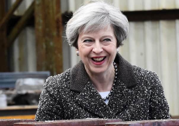 Britain's Prime Minister Theresa May laughs as she talks with a member of staff as she makes a general election campaign visit to a steel works in Newport, Wales. Picture: Getty