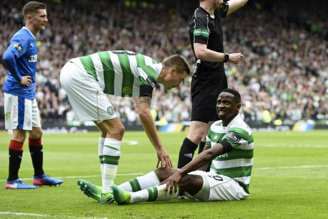 Moussa Dembele (right) sits on the ground after pulling up with an injury during the semi-final win over Rangers. Picture: SNS