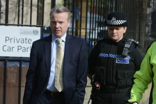 Police question a man outside the court, where Craig Whyte had arrived minutes before. Picture: SWNS