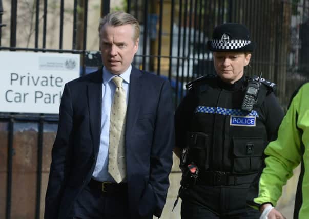 Police question a man outside the court, where Craig Whyte had arrived minutes before. Picture: SWNS