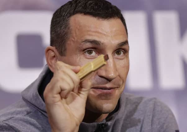 Wladimir Klitschko holds up a USB stick he said he's recorded his fight prediction on during a press conference with Anthony Joshua. Picture: AP
