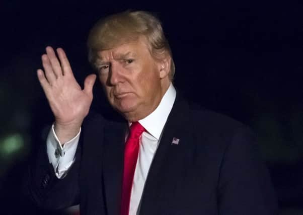 President Donald Trump waves as he walks across the south lawn of the White House in Washington late Saturday night, April 29, 2017, on this return from a rally in Harrisburg, Pa. (AP Photo/J. David Ake)