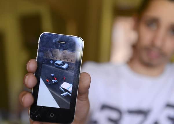Aa young man who filmed with a phone a violent police arrest shows the video on his iPhone.   (Photo credit should read ALAIN JOCARD/AFP/Getty Images)