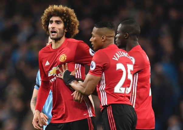 Manchester United midfielder Marouane Fellaini, left, reacts after being sent off for headbutting Manchester City striker Sergio Aguero. Picture: AFP/Getty