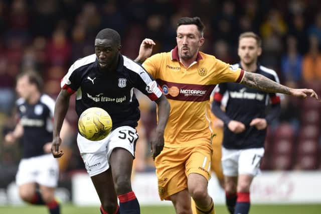 Dundee's Kevin Gomis in action with Motherwell's Ryan Bowman. Pic: SNS/Rob Casey