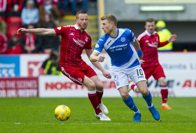 Aberdeen's Adam Rooney battles for the ball against St Johnstone's David Wotherspoon. Pic: SNS/Sammy Turner