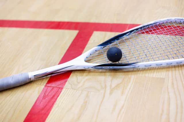squash racket and ball on the wooden background. Racquetball equipment. Squash ball and squash racket on the court next to a red line. Photo with selective focus