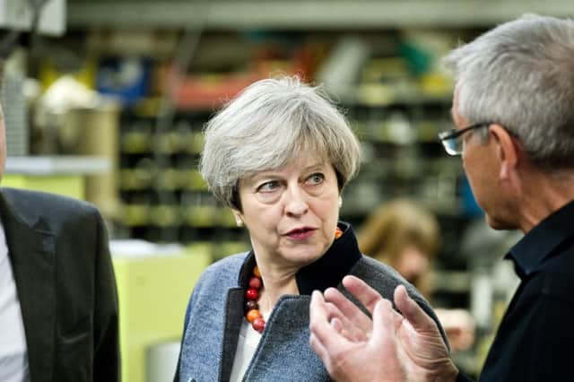 Prime Minister Theresa May talks to engineer Terry Fisher while out campaigning in Helston, Cornwall. Picture: SWNS