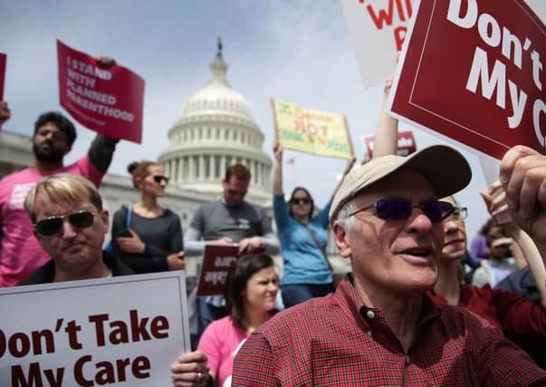 Activists hold signs during a Stop 'Trumpcare' rally. Picture: Getty