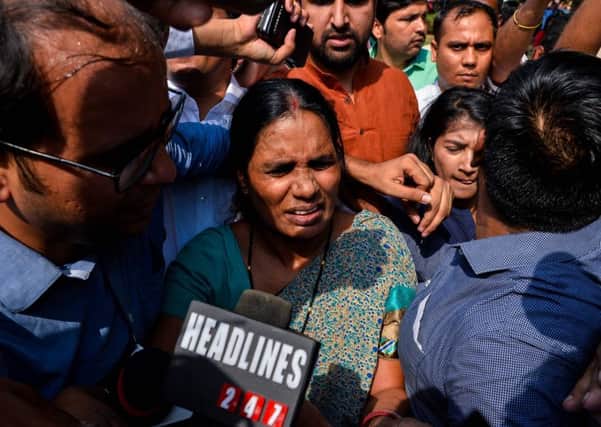 The mother of Indian gangrape victim 'Nirbhaya' walks through a crowd of media representatives as she leaves The Supreme Court in New Delhi. Picture: Getty