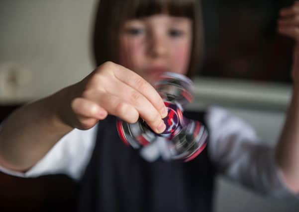 A child with a fidget spinner.