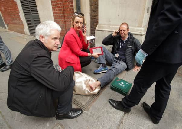 BBC's Laura Kuenssberg on the phone while her colleague, BBC cameraman Giles Wooltorton, sits on the floor after the car carrying Jeremy Corbyn ran over his foot as it arrived at the Institute of Engineering in London, where a Labour Party meeting is due to take place as they deal with the fallout from the sensational leak of its draft General Election manifesto (Yui Mok/PA Wire)