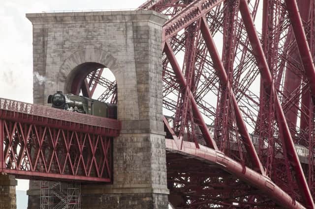 The Flying Scotsman locomotive hauls the Cathedrals Express excursion over the Forth Bridge today. Picture: SWNS