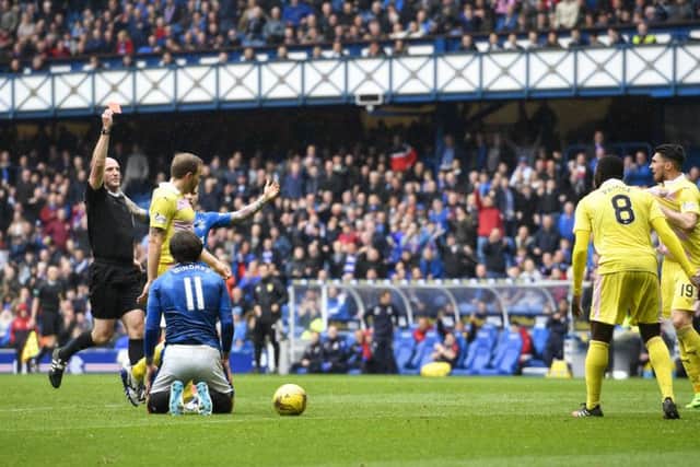 Prince Buaben is shown a red card by referee Bobby Madden. Pic: SNS/Rob Casey