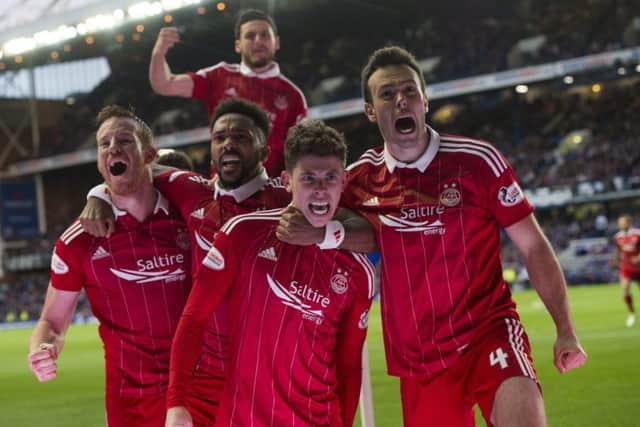 Ryan Christie, second from right, is mobbed by team-mates after putting Aberdeen 2-0 ahead at Ibrox. Picture: SNS
