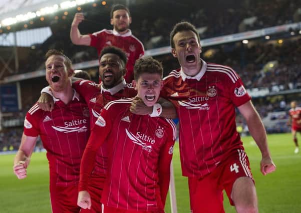 Ryan Christie, second from right, is mobbed by team-mates after putting Aberdeen 2-0 ahead at Ibrox. Picture: SNS