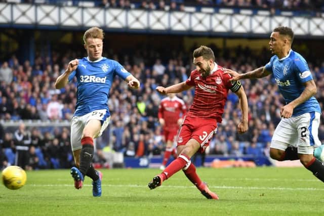 Aberdeen's Graeme Shinnie (centre) opens the scoring against Rangers at Ibrox. Picture: