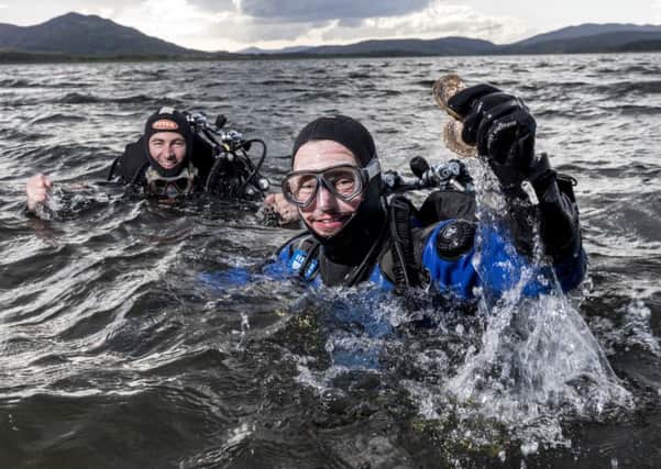 Divers hold up the first wild oysters to live in the Dornoch Firth for more than a century, after the species was reintroduced as part of a pioneering environmental project by Highland whisky firm Glenmorangie