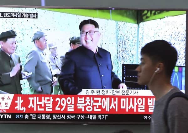 a man passes a TV news screen in Seoul showing an image of North Korean leader Kim Jong Un. Picture: AP