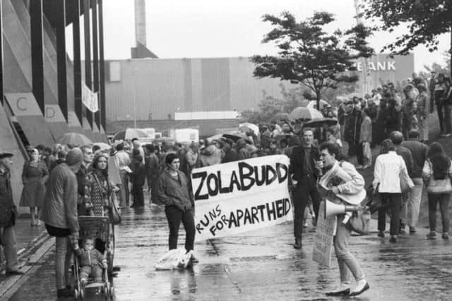 Protestors wave an anti-apartheid banner ahead of Zola Budd's race at Meadowbank in July 1985. Picture: Denis Straughan
