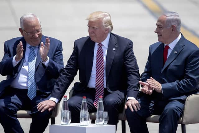 US President Donald Trump (C) and Israeli President Reuven Rivlin (L) and Israeli Prime Minister Benjamin Netanyahu (R) speak upon Trump's arrival at Ben Gurion International Airport in Tel Aviv on May 22, 2017, as part of his first trip overseas.  / AFP PHOTO / JACK GUEZJACK GUEZ/AFP/Getty Images