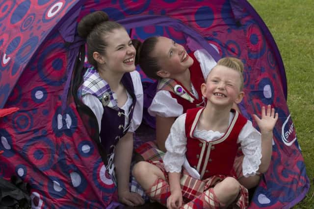 Erin Charker, Niamh Burns, and Olivia Burns shelter from Rain showers
. Picture: Mark F Gibson / Gibson Digital