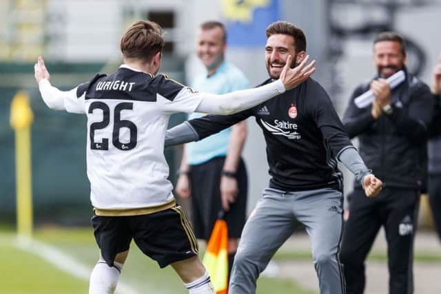 Derek McInnes, right, looks on as Scott Wright, left, celebrates with Graeme Shinnie. Picture: SNS