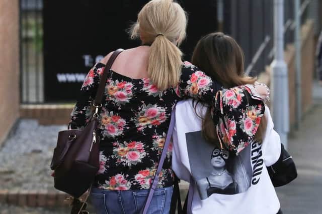 A mother who attended the concert with her 14-year-old daughter comforts the teenager on Tuesday morning as they leave a Manchester hotel. Picture: Getty Images