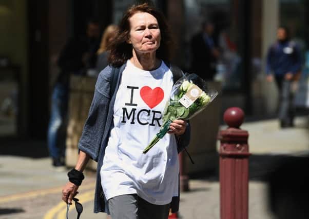 A woman wearing an 'I heart MCR' T-shirt makes her way to lay flowers in St Ann Square in Manchester. Picture: Jeff J Mitchell/Getty Images