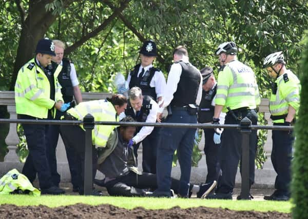 NOTE FACE PIXELATED BY THE PA PICTURE DESK

Police arrest a man who was carrying a knife near Buckingham Palace. Picture: Dominic Lipinski/PA Wire