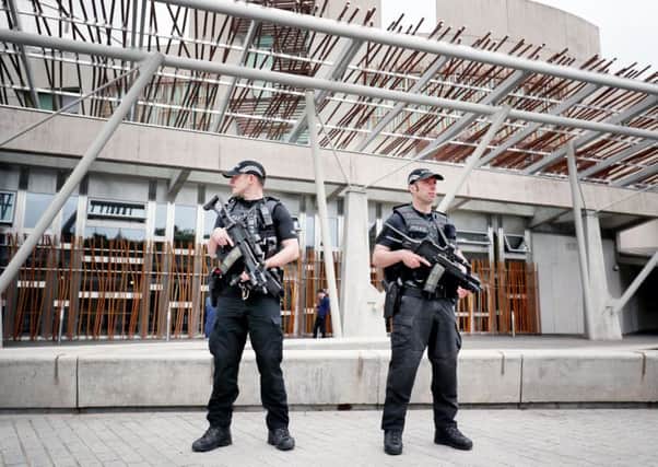 Armed police on patrol outside the Scottish Parliament building . Picture: PA