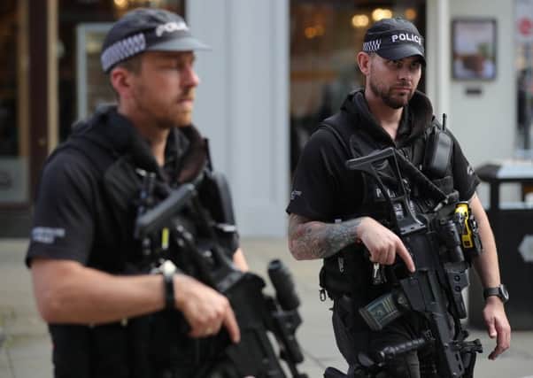 Armed police officers patrol around Manchester's St Ann's Square during a vigil on May 24. Picture: Getty Images