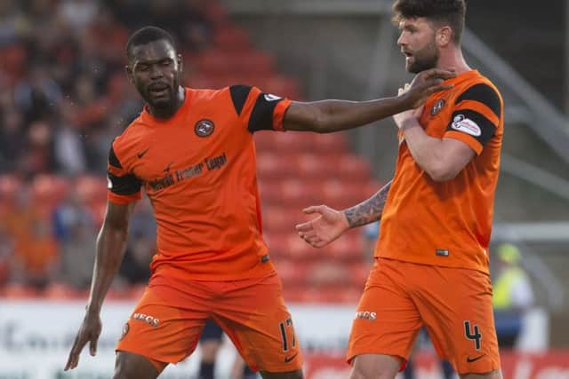 Wato Kuate, left, clashes with Dundee United team-mate Mark Durnan as he is substituted in the first leg of the Premiership play-off final. Picture: SNS