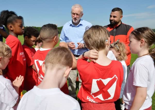 Corbyn speaks to young footballers during a visit to pitches at Hackney Marshes in London yesterday. Picture: John Stillwell/PA