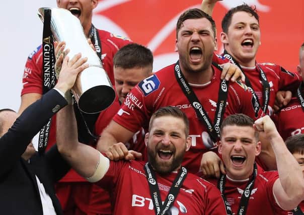 Scarlets' John Barclay lifts the trophy with his  team-mates. Picture: PA