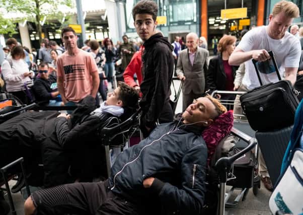 People lie on their luggage as they queue outside Heathrow Airport's Terminal 5. Picture: Getty Images