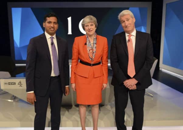 Britain's Prime Minister Theresa May, centre, poses for a photograph with broadcaster Jeremy Paxman, right, and Sky News political editor Faisal Islam. (Stefan Rousseau/ Pool Photo via AP)