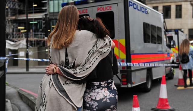 Two women hug after bringing flowers to add to tributes laid on the north side of London Bridge following last night's terrorist incident. Picture: David Mirzoeff/PA Wire