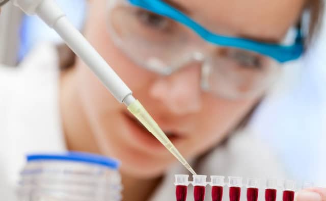 A laboratory assistant analyzing a blood sample.