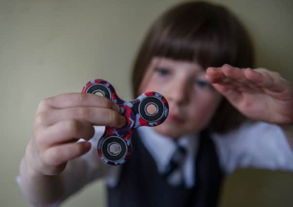 Children find it hard to explain why they love fidget spinners. Picture: John Devlin